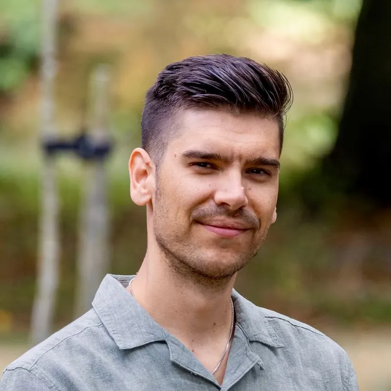 Headshot of Rick Doesburg wearing a green shirt and smiling at the camera